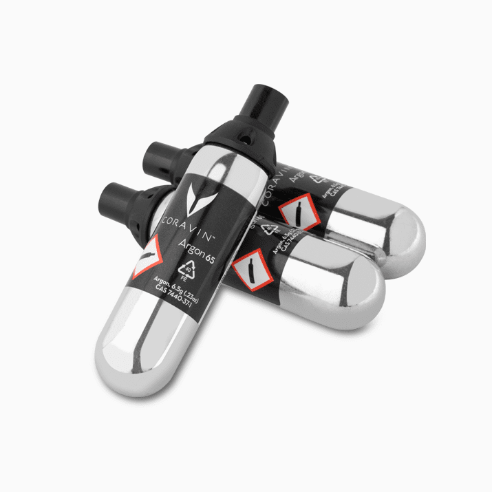 Three Coravin Argon 6.5 gas canisters, featuring a chrome finish and black labeling with hazard symbols.