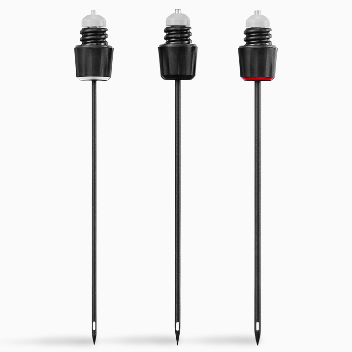 Three black beverage pourers with different colored tops: clear, black, and red, each mounted on a long black spike.