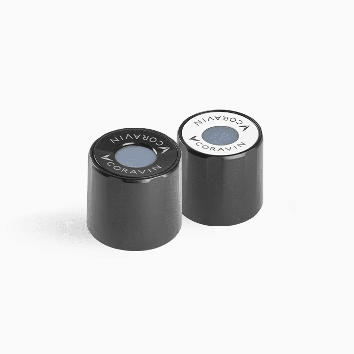 Two Coravin wine capsule tops with a black and white color scheme, featuring the Coravin logo on each.