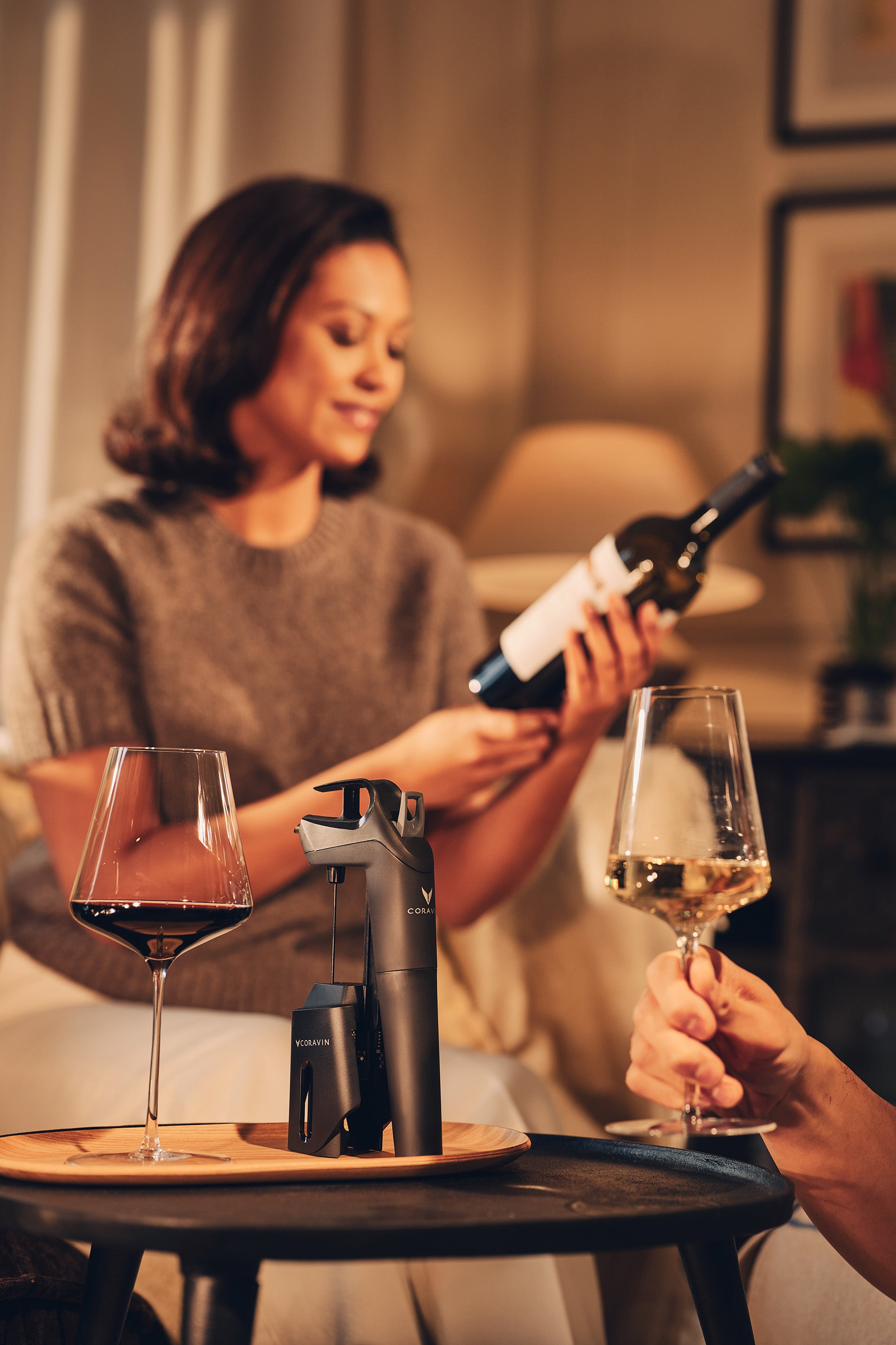 Coravin Three Plus on side table with white and red wine in a glass